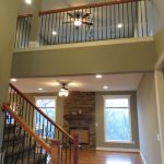 A view of the 2nd floor with a ceiling fan and a balcony- Olathe, KS interior house painters