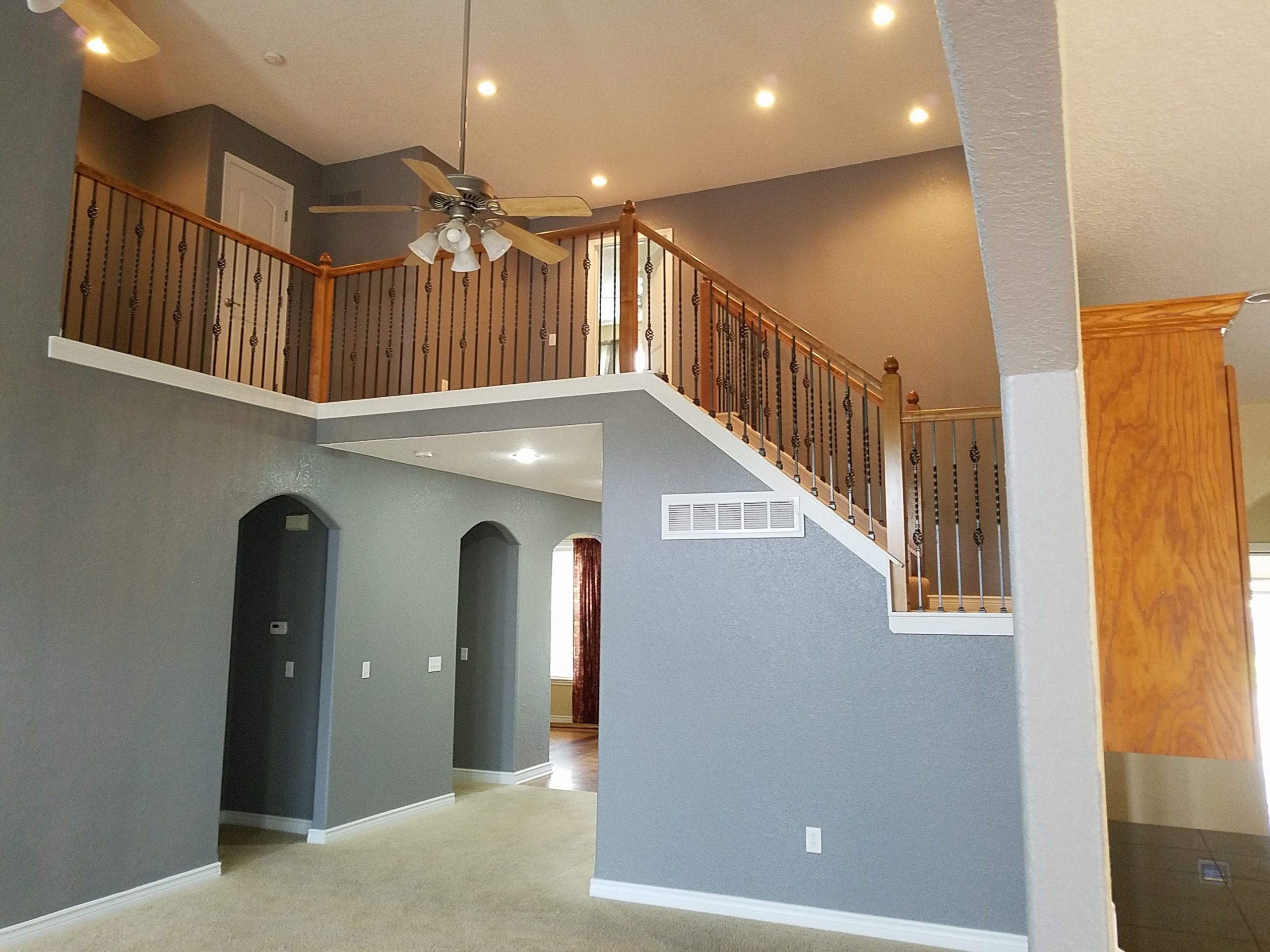 A room with a staircase and a ceiling fan- Lawrence, KS painting services