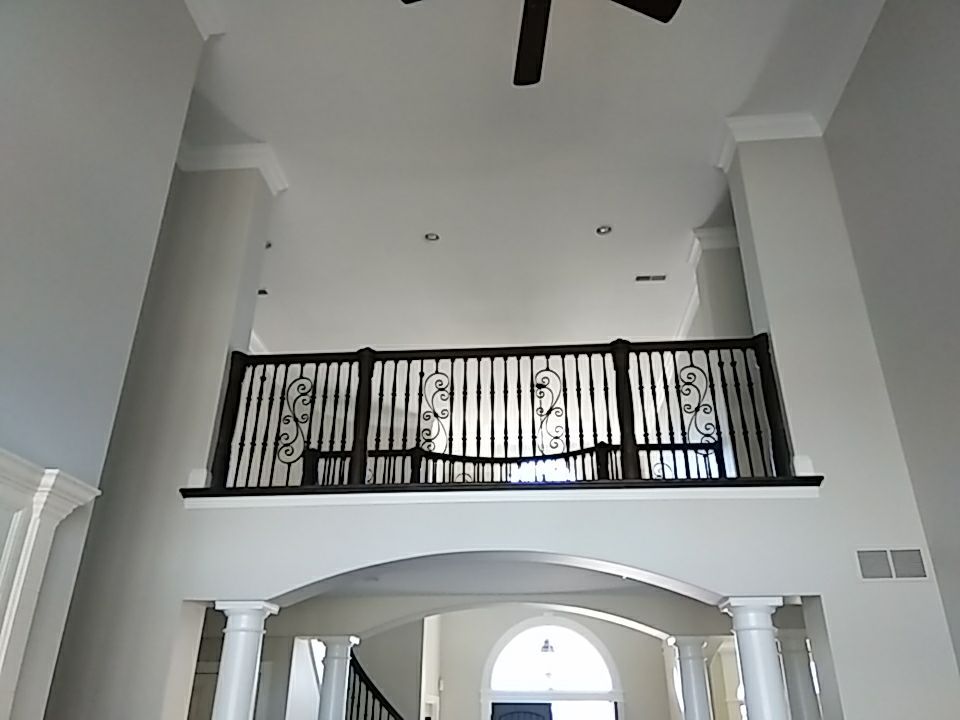A view of the 2nd floor with a ceiling fan and a balcony- Topeka, KS interior house painters