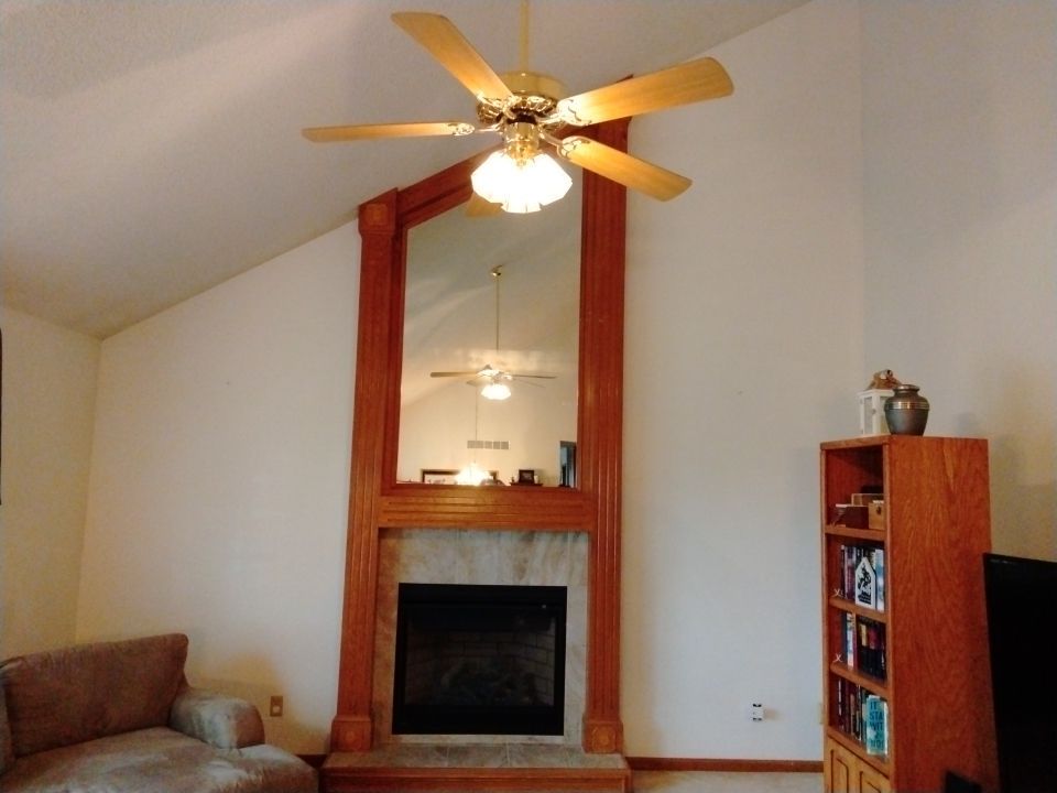 A fireplace in a room with a ceiling fan- Interior House Painters in Topeka, KS