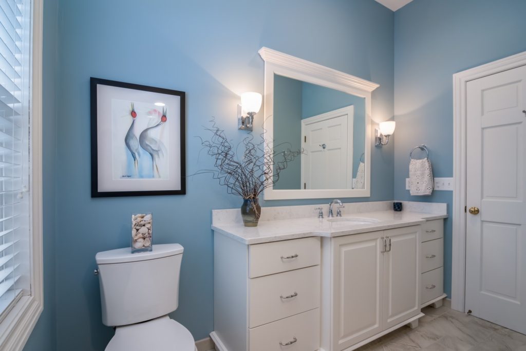 A sky blue painted bathroom accented by a white cabinet painters in Lawrence, KS