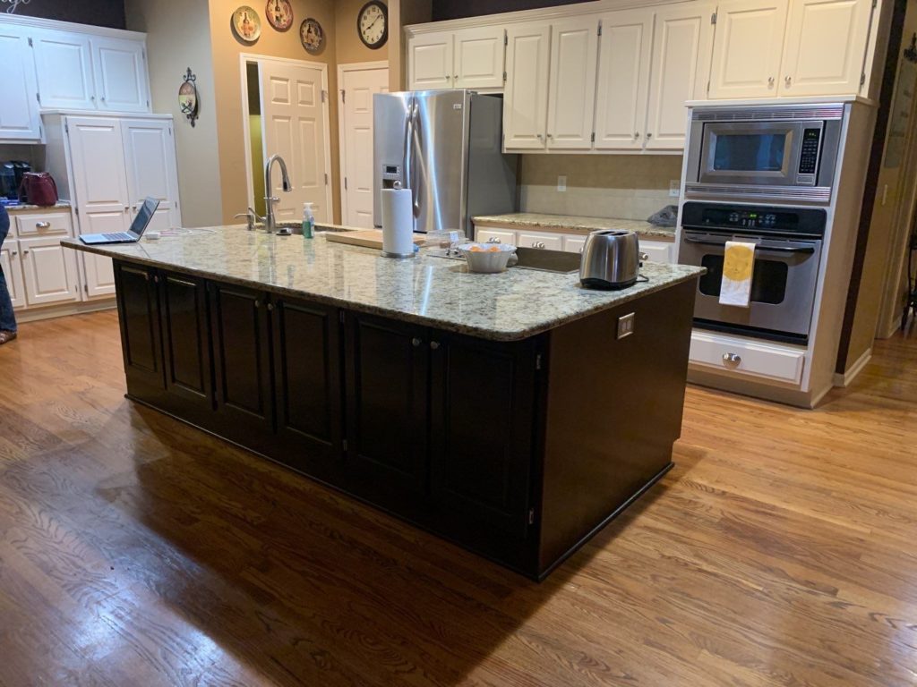 A kitchen with marble countertop and white cabinets- Lawrence, KS Cabinet Painters