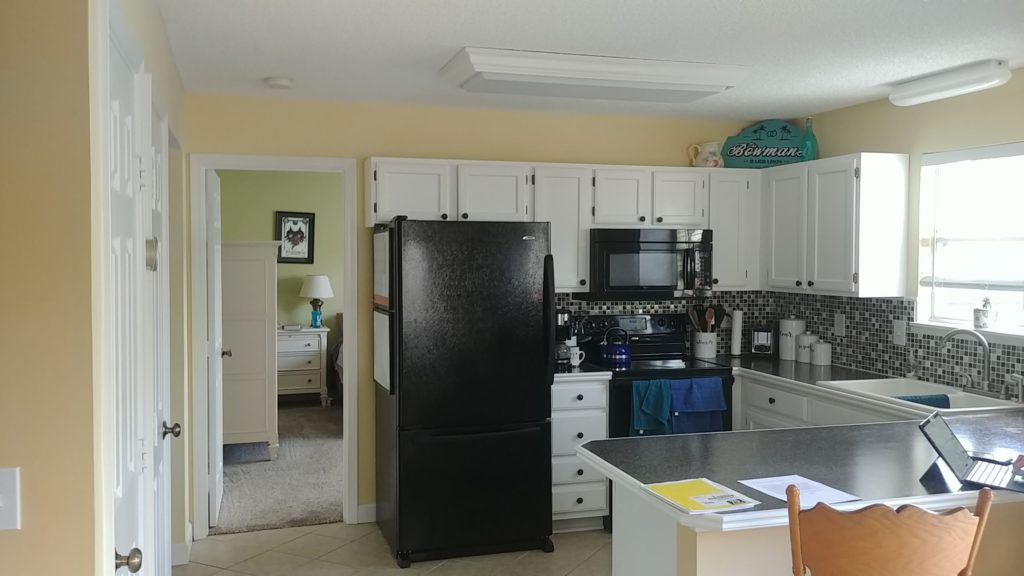 A yellow painted kitchen with white cabinets- Kitchen Cabinet Painters in Lawrence, KS