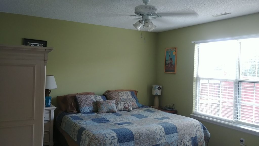 A yellow painted bedroom with white windows- Interior House Painters in Lenexa