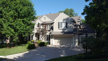 A two storey house with driveway- Exterior House Painters in Overland Park, KS