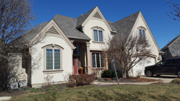 A white painted house exterior with lawn in front- Lawrence, KS Exterior House Painting Services